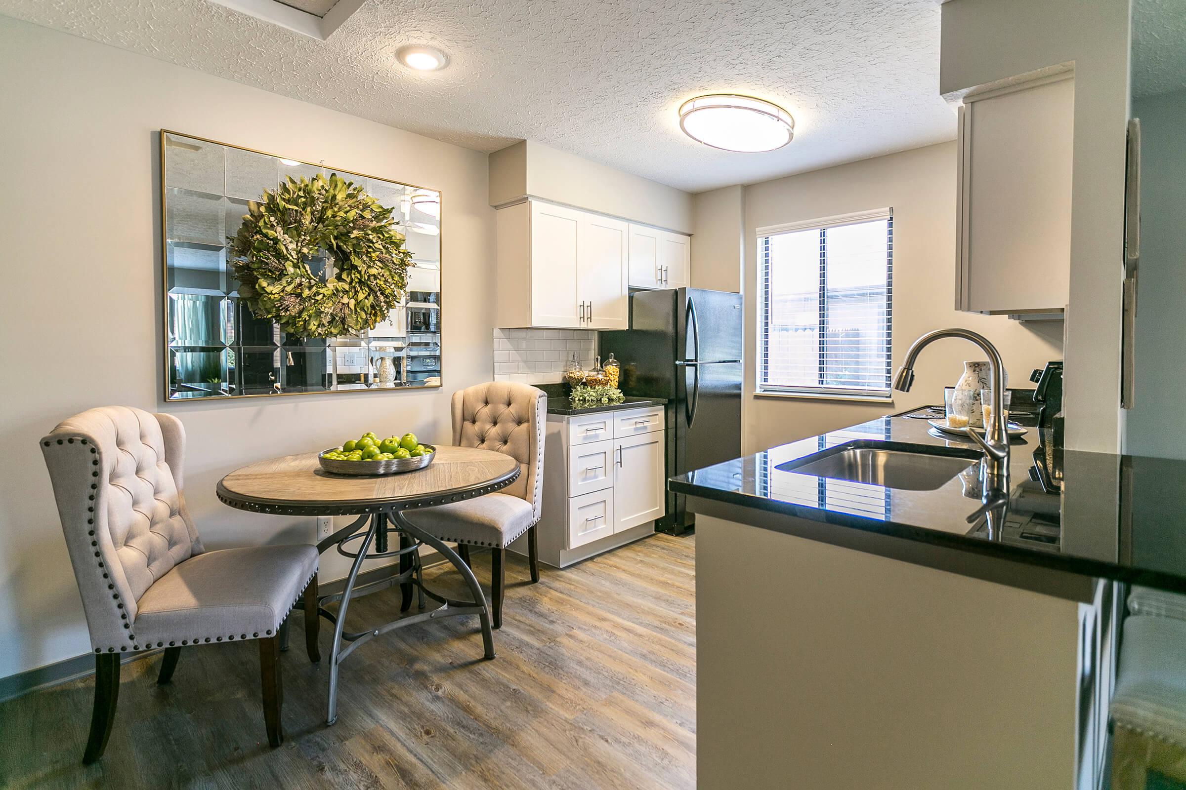 Dining area and modern kitchen with white cabinets.